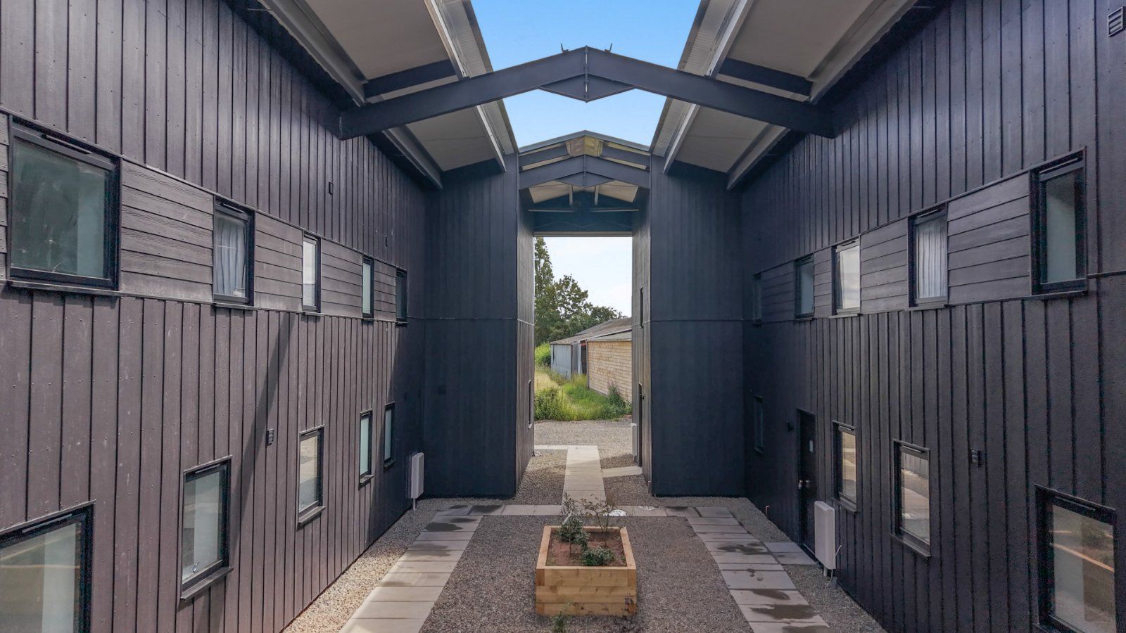 Timber-clad courtyard between barns